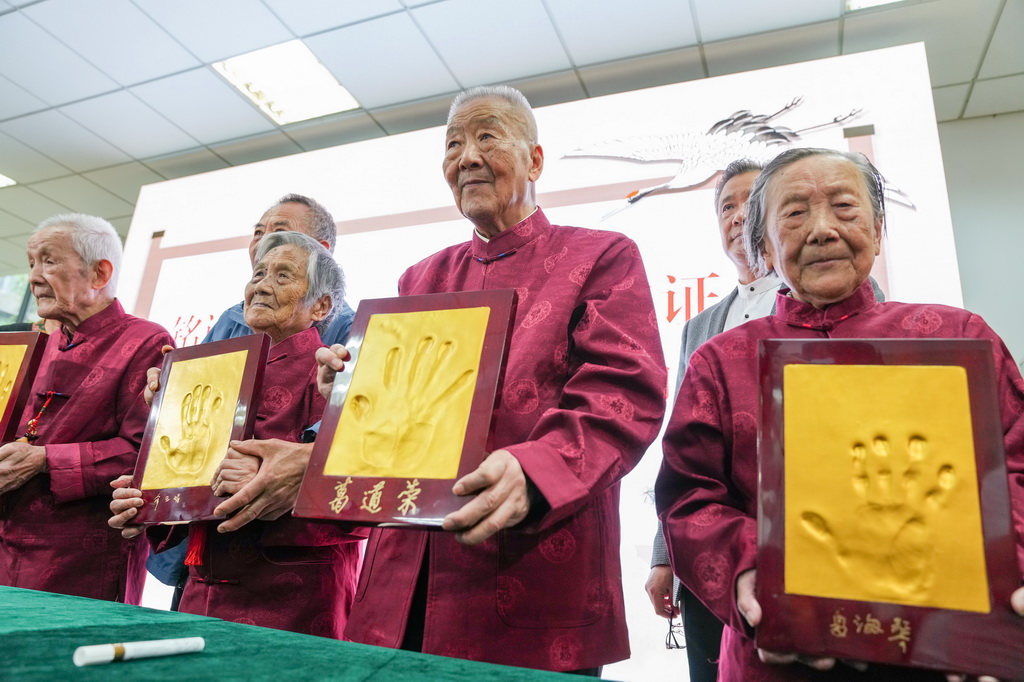 2022年10月4日，南京大屠杀幸存者夏淑琴、葛道荣、薛玉娟和王义隆（前排，从右到左）在侵华日军南京大屠杀遇难同胞纪念馆举办的重阳节活动上展示手印。新华社记者 李博 摄